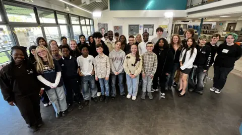 A group of children posing for a photo in a youth club.