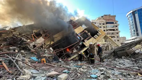 Members of the Lebanese Civil Defence inspect a damaged building after an Israeli strike on Beirut's southern suburbs, Lebanon (9 March 2026)