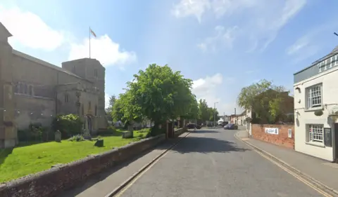 Google village of southminster in Essex. showing church n the left and view along the end of the high street