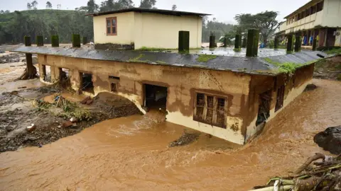 EPA Floodwater flows past a house after a landslide in Mylambadi, Wayanad district, Kerala, southern India, July 30.