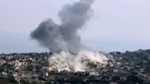 EPA Plums of grey and white smoke rise from buildings in Lebanon.