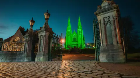 PA Media St Patrick's Church of Ireland Cathedral in Armagh, glowing green in celebration of St Patrick's Day.