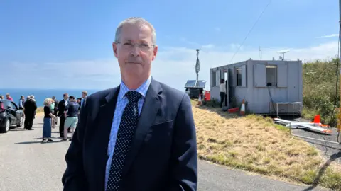 John Nicholas outside a control cabin 