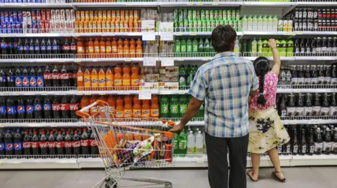 Getty Images A father a daughter shop in the beverage aisle inside a supermarket in India.