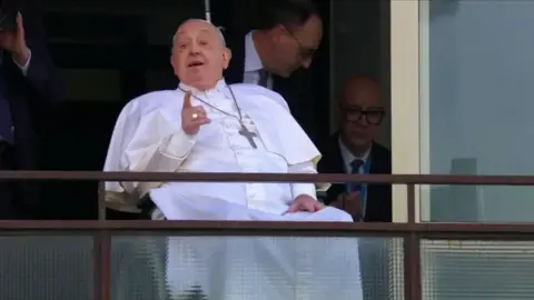 Pope Francis waving on the hospital balcony