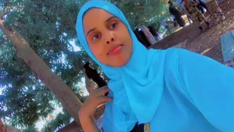 Fathi Hussein, posing for a selfie wearing a blue headscarf. 