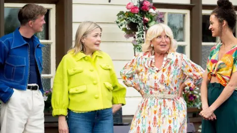 Does a Welsh accent help or is it a hindrance on the show? 10 Stephen (left), Harriet, Fiona and Roxy stand on a train platform. Fiona wears a floral midi dress and has blonde short hair and a fringe, while Harriet wears a yellow short jacket. Stephen has short mousy brown hair and wears white jeans and a blue denim jacket. Roxy wears a brightly patterned blouse and smiles at the others.