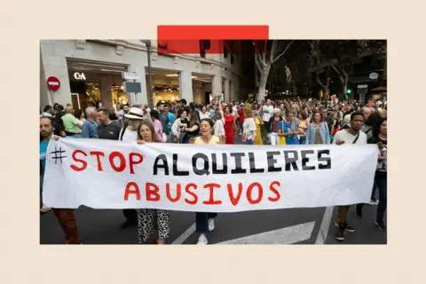 Getty Images Protesters in Majorca carrying a banner that says "stop alquileres abusivos" which translates as "stop abusive rentals"