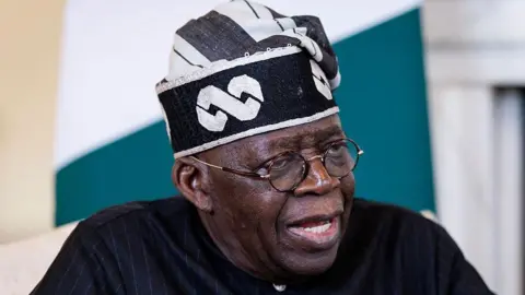Bola Ahmed Tinubu wearing a black and white hat.