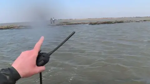 RNLI Two women cut off by tide as rescuer holds walkie talkie