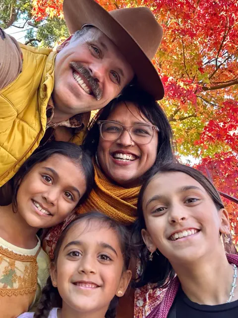 Supplied by Seema Patel Seema Patel smiles, surrounded by her three daughters and husband, with the fall foliage in the background