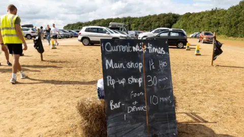 Getty Images The car park at the popular Diddly Squat farm shop near to Chipping Norton in the Cotswolds, blackboard with waiting times to gate into the shop. 