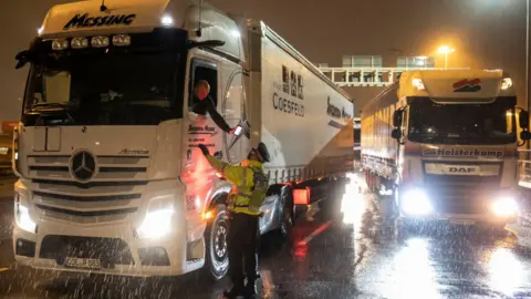 Getty Images A police officer checks a lorry driver's phone at Dover Port, Kent, on Tuesday evening