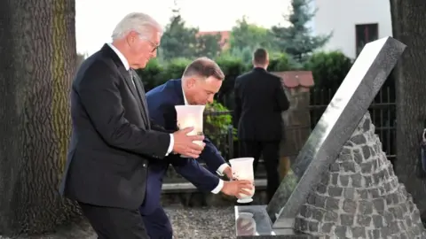 EPA Mr Steinmeier and Mr Duda lit candles at a commemorative memorial