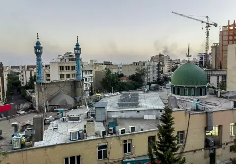 Xinhua/Shutterstock Mobile phone photo shows smoke rising in Tehran, Iran (17 June 2025)