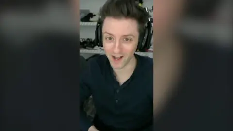 YouTube streamer Datto wearing a black shirt and gaming headphones.