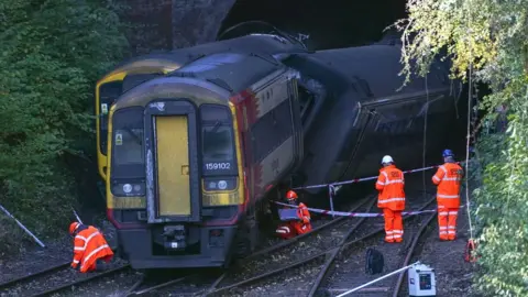 PA Media Investigators stood by trains at the scene of the crash