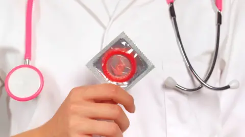 Getty Images Stock image of doctor holding up condom 