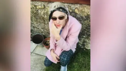 FAMILY HANDOUT Photo of Billy kneeling down on the floor. He is wearing sunglasses and a bandana.