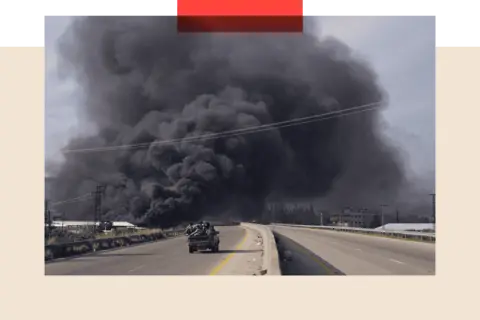 Reuters A massive cloud of black smoke behind a car