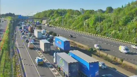 Build up of slow traffic on motorway with several lorries in the queue