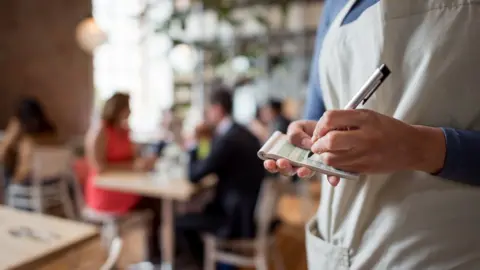 Getty Images Waiter in a restaurant