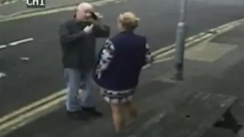 CPS Stephanie Langley and Matthew Bryant on a pavement facing each other, he is on the phone