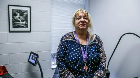 BBC Patient sits on table