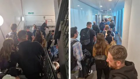 Martin Slade Two pictures of passengers being evacuated from Bristol Airport. There are crowds. 