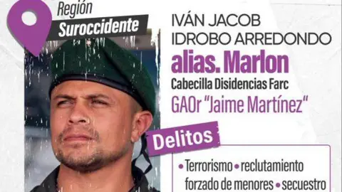 A "Wanted" posted bears a photo and the name of the man known as alias "Marlon". The posted, issued by the Colombian defence ministry accuses him of a number of crimes, including "terrorism, forced recruitment of children, kidnapping". Alias Marlon is shown with his brow furrowed and wearing an olive green beret. He has a goatee beard and a closely-cropped moustache.