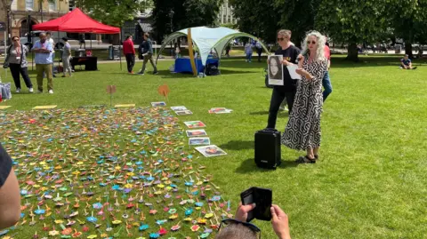 Anne-Marie Cockburn reading at the event, next to a picture of her daughter 