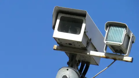 A CCTV camera and light with blue background 