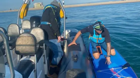 Will Chetwode Joe Cartwright on a paddleboard by a boat on the English Channel