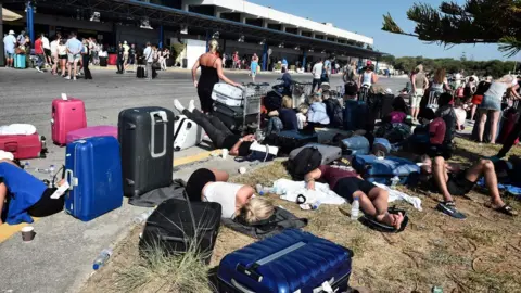 AFP/Getty Images Tourists gather outside terminal buildings at an airport on the island of Kos following an earthquake, 21 July 2017