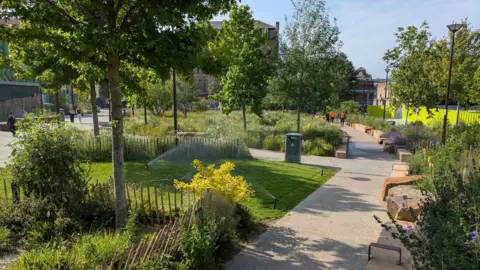 Nottingham City Council Green Heart in summer, showing flowers, trees and lawn areas divided by paths