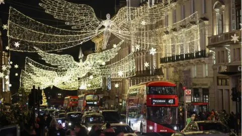 Getty Images Buses pass under Christmas lights near Piccadilly Circus on December 3, 2022 in London, England.