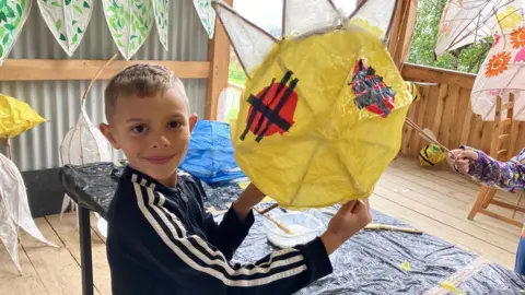 BBC Young boy holding up his creation