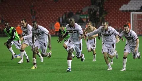 Getty Images Nathaniel Wedderburn of Northampton Town and his team mates celebrate after winning a penalty shootout during the Carling Cup Third Round game between Liverpool and Northampton Town at Anfield