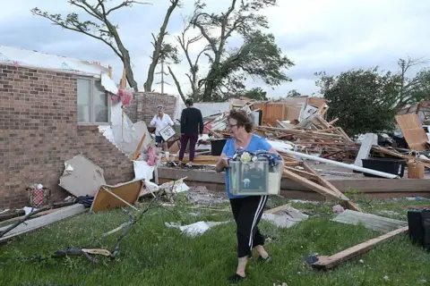 Reuters Volunteers clean up after a tornado touched down in Nevada, Iowa