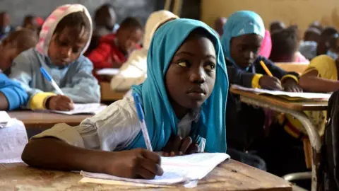AFP Pupils write on their notebook as they attend class at a primary school in Pikine, on the outskirts of Dakar, on January 30, 2018.