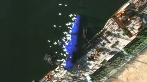 A handout satellite image made available by Maxar Technologies shows a new North Korean warship at the harbour 25 May 2025 after an accident during the launch ceremony in Chongjin, North Korea, 21 May