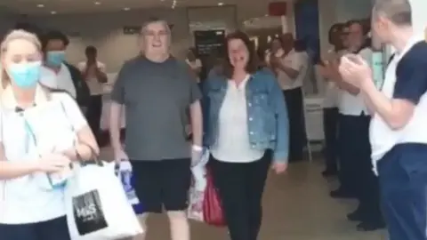 NHS Gerard Small leaving hospital with his wife Lynn