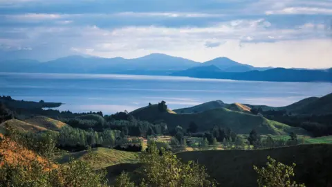 Getty Images Lake Taupō is seen from a distance. Mountains are in the background.