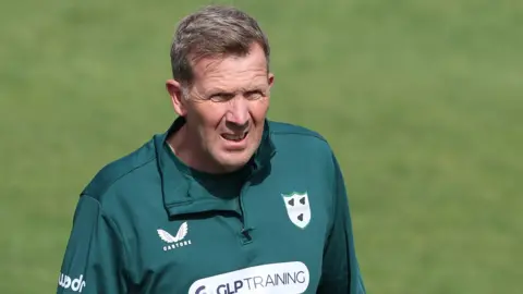 Alan Richardson wearing a green Worcestershire training top looks on