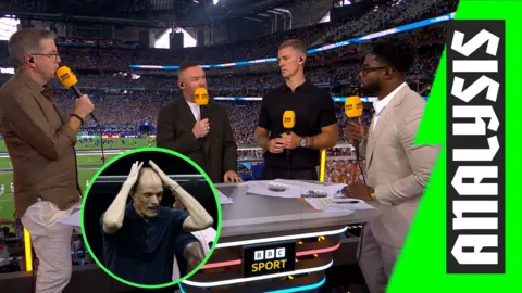 Mark Chapman, Wayne Rooney, Joe Hart, and Micah Richards standing over the pitch at the Atlanta Stadium.