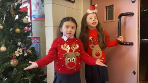 Riverdale Primary School Two pupils dressed in Christmas jumpers