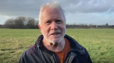 Graham Lyon from York wearing a blue anorak with a field backdrop 