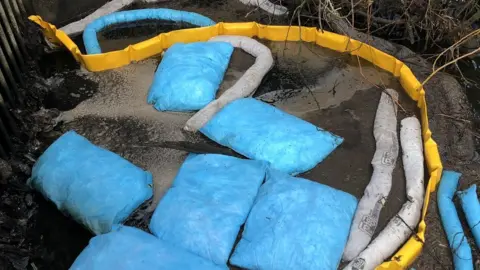 Bags to collect oil which has seeped into the River Yare, Norwich