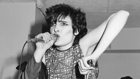 Pete Hill Siouxsie and the Banshees performing at The Limit club - lead singer Siouxsie Sioux singing into a microphone 