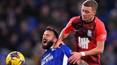  Manolis Siopis of Cardiff City battles for possession with Jay Stansfield of Birmingham City during the Sky Bet Championship match between Cardiff City and Birmingham City at Cardiff City Stadium on December 13, 2023 in Cardiff, Wales. 